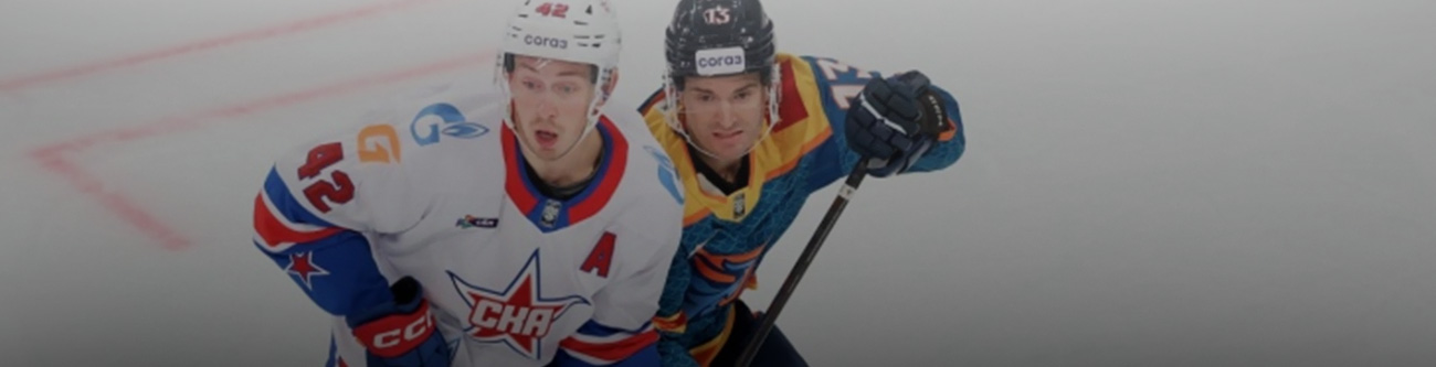На изображении два хоккеиста в игровом моменте. Один из них в форме белого цвета с логотипом ЦСКА, другой — в форме синих и желтых оттенков. Спортсмены находятся на льду во время матча
