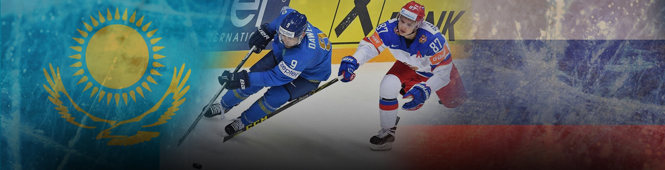 Хоккейный матч между двумя командами: одна в форме сине-голубого цвета с флагом Казахстана, другая в красно-синей форме с флагом России. Игроки соревнуются за шайбу на фоне флагов двух стран