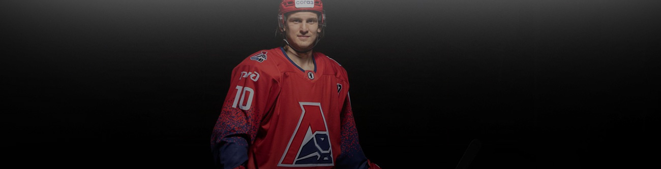 Хоккеист в красной форме команды с логотипом в виде буквы А на тёмном фоне. На его свитере заметен номер 10